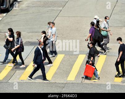 Hong Kong, Cina. 1 aprile 2021. Le persone che indossano maschere facciali camminano su una strada a Hong Kong, Cina meridionale, 1 aprile 2021. Il Centro per la protezione della salute (CHP) di Hong Kong ha segnalato 13 casi confermati aggiuntivi di COVID-19 giovedì, portando il totale a 11,480. Dei nuovi casi, 11 sono stati importati e due sono stati trasmessi localmente e hanno avuto origini sconosciute, secondo una dichiarazione del CHP. Credit: Lo Ping Fai/Xinhua/Alamy Live News Foto Stock