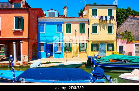 Accoglienti case colorate e canale con barche a Burano Island a Venezia, Italia. Paesaggio urbano, vista veneziana Foto Stock