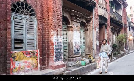 Kolkata, Bengala Occidentale, India - Gennaio 2018: Un uomo indiano che cammina attraverso la vecchia architettura vintage delle case in un vicolo della città di Kolkata. Foto Stock