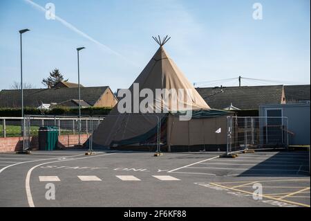 Amamble, Northumberland, UK - 21 marzo 2021: Covid 19 Centro di test e vaccinazione. Tenda temporanea struttura racchiusa dietro recinzione metallica. Foto Stock