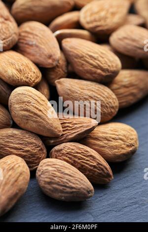 Dado a mandorla. Mandorle grezze noci mucchio su ardesia background.Nuts e semi closeup.Tasty snack. Grassi sani. Foto Stock