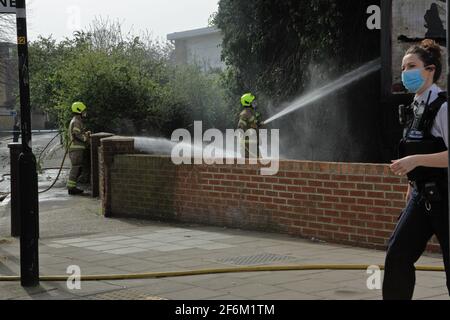 Londra (UK)1 aprile 2021: La Brigata dei vigili del fuoco di Londra assiste e spegne un incendio in un cespuglio e un tabellone sulla Old Kent Road a Londra. Foto Stock