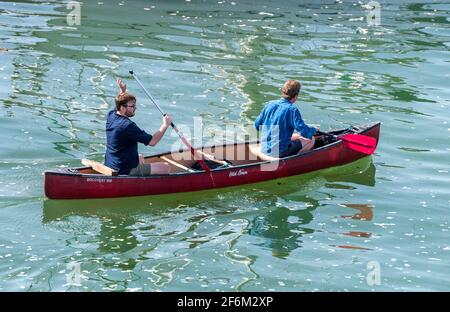 due uomini che pedalano in un kayak canadese di stile tradizionale un mare calmo Foto Stock