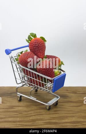 Un carrello pieno di fragole fresche con un neutro sfondo e spazio di copia Foto Stock