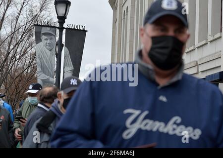 New York, Stati Uniti. 01 Aprile 2021. Un banner con un ritratto della leggenda di Yankee Babe Ruth guarda come i fan aspettano in fila per partecipare alla partita di baseball del giorno di apertura degli Yankees di New York contro i Toronto Blue Jays nel quartiere Bronx di New York City, NY, 1 aprile 2021. Chiuso completamente la scorsa stagione a causa della pandemia COVID-19, un numero limitato di tifosi sarà in grado di partecipare alla prima partita di casa, che dovrà fornire la prova di un negativo test COVID-19, avere la loro temperatura all'ingresso e indossare una maschera mentre all'interno dello stadio. (Foto di Anthony Behar/Sipa USA) Credit: Sipa USA/Alamy Live News Foto Stock