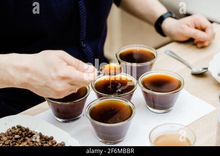 Barista professionista che verifica il gusto di un nuovo caffè. Foto Stock