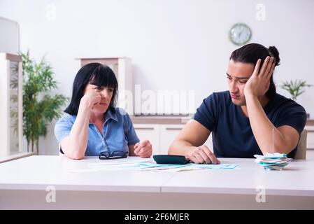 Donna ritirata e suo figlio giovane nel concetto di pianificazione del bilancio Foto Stock