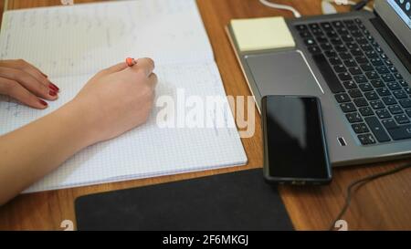 Donna che studia a casa mentre usa il notebook per la scuola remota, covid-19 pandemia di distanza sociale Foto Stock