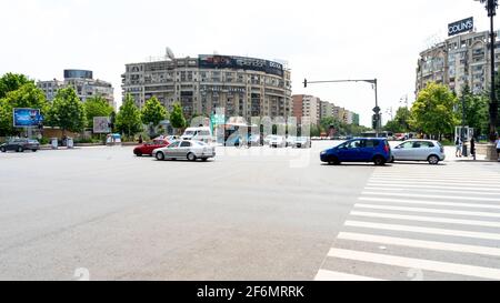 Traffico su Union Square (Piata Unirii), bisecato da Unirii Boulevard, in una giornata soleggiata e limpida, Bucarest, Romania Foto Stock