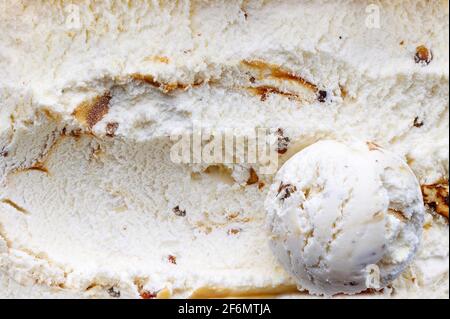 paletta per gelato su sfondo gelato di noce caramellato e sciroppo d'acero, vista dall'alto Foto Stock