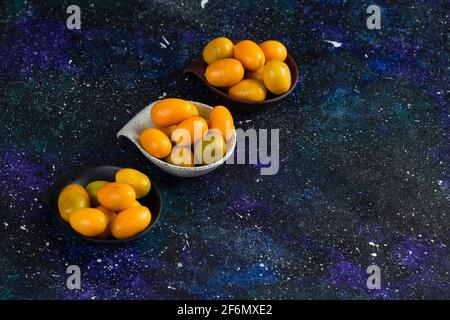 Primo piano foto di kumquat freschi su sfondo blu Foto Stock