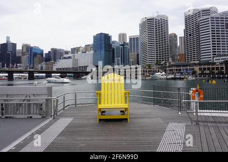 Giant Yellow Chair fronteggia lo skyline di Sydney a Darling Harbour Foto Stock