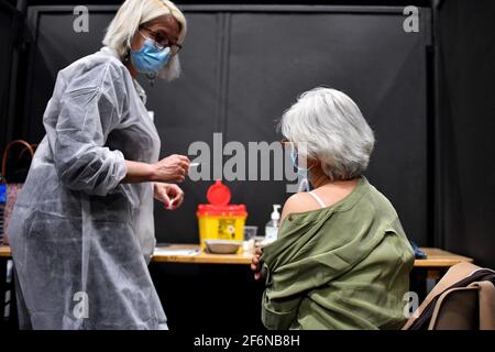 Un membro del personale medico vaccina un paziente in un centro di vaccinazione Covid-19, situato presso la sala concerti Palais Nikaia a Nizza, durante il terzo fine settimana di blocco attuato per frenare la diffusione del romanzo avirus, nella città della costa azzurra di Nizza, Francia meridionale, il 1 aprile 2021. Foto di Lionel Urman/ABACAPRESS.COM Foto Stock