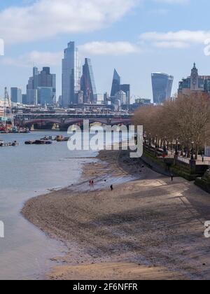 Tamigi a Waterloo vicino al Teatro Nazionale con bassa marea con una vista dello skyline di London City Square Mile e degli edifici alti, senza persone Foto Stock