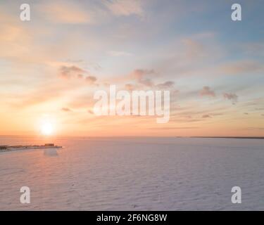 Ghiaccio sul mare ghiacciato e cielo dai colori vivaci al tramonto. Vista panoramica aerea, composizione quadrata Foto Stock