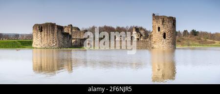 Flint castello in alta marea primavera, costa del Galles del Nord Foto Stock