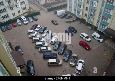 Ivano-Frankivsk, Ucraina - Ottobre, 2019: Vista aerea del parcheggio scoperto circondato da alti edifici residenziali. Cortile con auto parcheggiate Foto Stock