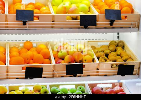 Varietà di frutta diverse arance, kiwi, mele, melograni sugli scaffali del supermercato. Vitamine e minerali. Foto Stock