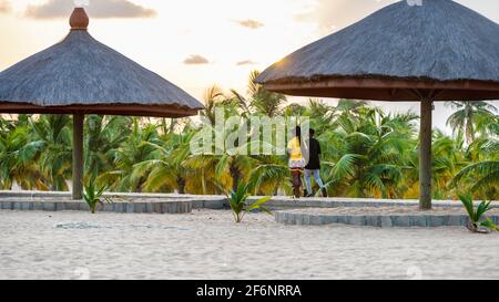 Giovane coppia africana che cammina sulla strada della spiaggia a piedi al tramonto a Keta Ghana Africa occidentale, 2020 novembre 11 Foto Stock