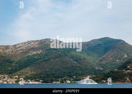 Un grande yacht privato a più piani di colore bianco naviga sulla baia di Cattaro in Montenegro. Il concetto di vita ricca di milionari. Foto Stock