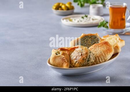 Mediorientale, colazione arabica con pasticceria tradizionale e labneh. Pasties, fatayer o samosa con spinaci, patate e formaggio, manaqeesh zaa Foto Stock
