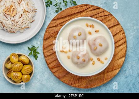 Piatto mediorientale Kibbeh bi Laban . Carne macinata con grano saraceno e salsa allo yogurt. Vista dall'alto Foto Stock