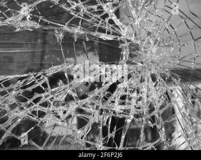 foto in bianco e nero di vetro rotto, motivo radiale con crepe Foto Stock