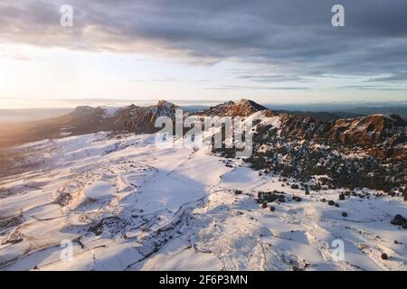 Vista aerea delle montagne innevate al tramonto. Foto di alta qualità Foto Stock