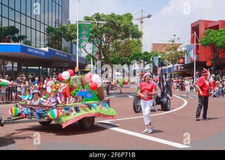 Una parata di Natale a Tauranga, Nuova Zelanda. I bambini possono viaggiare in un rimorchio pieno di regali Foto Stock