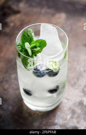 Cocktail mojito mirtillo su sfondo ligneo. Messa a fuoco selettiva. Profondità di campo poco profonda. Foto Stock