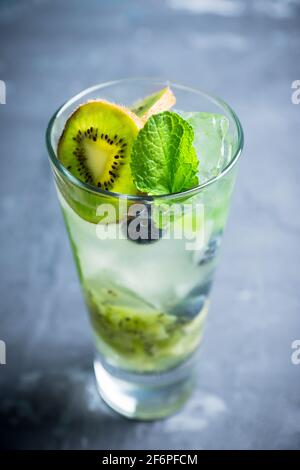 Fresco cocktail estivo con mirtillo e kiwi su sfondo ligneo. Messa a fuoco selettiva. Profondità di campo poco profonda. Foto Stock