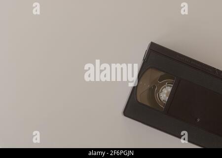 Vecchio nastro VHS Video nero, cassetta su sfondo bianco, posa piana. I nastri VHS utilizzati per la riproduzione di film e filmati hanno raggiunto il picco negli anni '90 Foto Stock