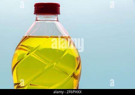 bottiglie di plastica con olio di soia commestibile su fondo blu. Olio vegetale. L'olio di soia è un tipo di olio vegetale estratto da semi di soia ed è ricco di poly Foto Stock