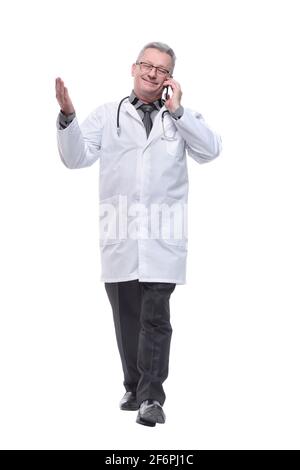 Medio età bello grigio-capelli medico uomo parlante smartphone isolato bianco sfondo Foto Stock