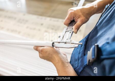 il tecnico addetto alla fabbrica controlla la qualità dei tubi in polipropilene Foto Stock