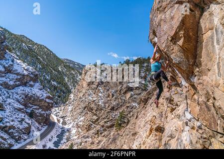 Donna rock climber la naviga su una parete rocciosa in Golden, CO Foto Stock