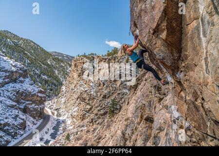 Donna rock climber la naviga su una parete rocciosa in Golden, CO Foto Stock