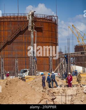 Aktau, Kazakhstan - 19 maggio 2012 costruzione di un moderno impianto di bitume asfaltico. Creazione di colonne da costruzione. Pompa per calcestruzzo che riempie cemento in forme. Arrugginito Foto Stock