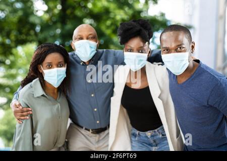Felice gruppo di amici africani che hanno divertimento indossando maschera facciale Foto Stock