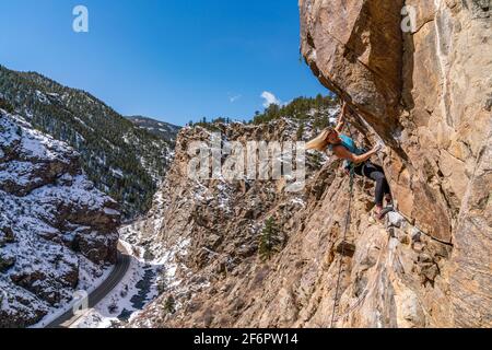 Donna rock climber la naviga su una parete rocciosa in Golden, CO Foto Stock