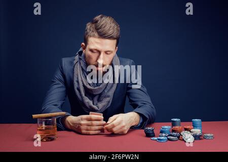 Elegante uomo bearded che gioca nel casinò scuro Foto Stock