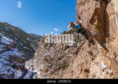 Donna rock climber la naviga su una parete rocciosa in Golden, CO Foto Stock