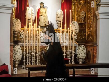 Malaga, Spagna. 02 aprile 2021. Una donna che indossa un abito da mantilla e una maschera facciale è vista pregare all'interno della chiesa di Santo Cristo de la Salud mentre partecipa a un evento sociale per promuovere l'uso della mantilla durante il Giovedì Santo e Venerdì Santo. Tradizionalmente in Spagna, le donne indossano abiti da mantilla come cordoglio mentre accompagnano la Vergine durante le processioni della settimana Santa. (Foto di Jesus Merida/SOPA Images/Sipa USA) Credit: Sipa USA/Alamy Live News Foto Stock