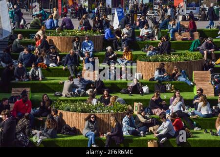 Londra, Regno Unito. 02 aprile 2021. La gente gode del sole sui gradini di Granary Square a King's Cross, Londra. Affacciato sul canale di Regent e coperto di erba artificiale dalla primavera fino all'inverno, i famosi scalini attirano ancora una volta la folla mentre le restrizioni di blocco del Regno Unito sono rilassate. (Foto di Vuk Valcic/SOPA Images/Sipa USA) Credit: Sipa USA/Alamy Live News Foto Stock