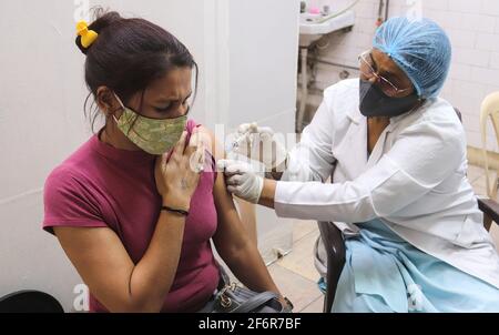 Nuova Delhi, India. 02 aprile 2021. Un operatore sanitario somministra una dose di vaccino Covisield (sviluppato dal Serum Institute) a una donna durante un viaggio di vaccinazione presso un dispensario governativo. L'India ha registrato 81,446 nuovi casi di Coronavirus Covid-19 il 01, il 2021 aprile e 469 decessi in 24 ore. Credit: SOPA Images Limited/Alamy Live News Foto Stock