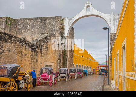 Cavalli e carrozze in attesa di turisti al Convento de San Antonio de Padova, monastero francescano nella Città gialla di Izamal, Yucatán, Messico Foto Stock