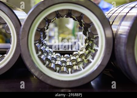 Impianto di produzione di cuscinetti. Primo piano del cuscinetto del rullo. Bassa profondità di campo. Rulli della terza fila in primo piano. Foto Stock