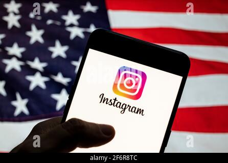 In questa illustrazione fotografica il servizio di social network americano per la condivisione di foto e video di proprietà di Facebook, il logo Instagram viene visualizzato su un dispositivo mobile Android con la bandiera degli Stati Uniti d'America (USA), comunemente nota come Stati Uniti (USA o USA), sullo sfondo. Foto Stock