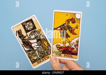 Mano che tiene due carte tarocchi, morte e il Fool Foto Stock
