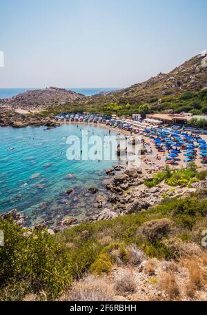 Bellissima spiaggia della baia di Ladiko con acque blu limpide vicino a Faliraki, isola di Rodi, Grecia in una giornata estiva soleggiata. Foto Stock